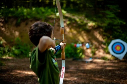 boys with bow and arrow practicing archery