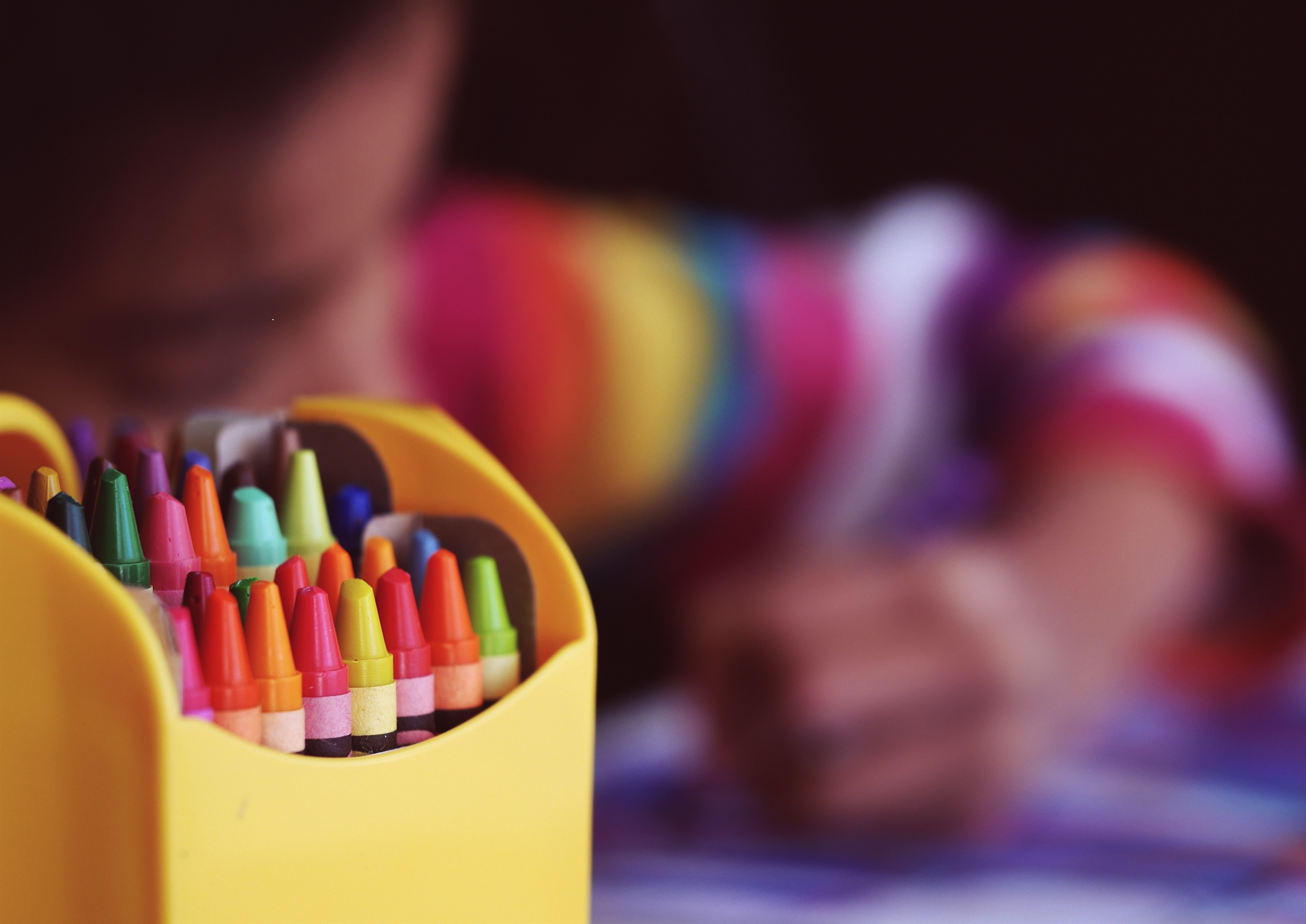 child coloring with crayons in foreground