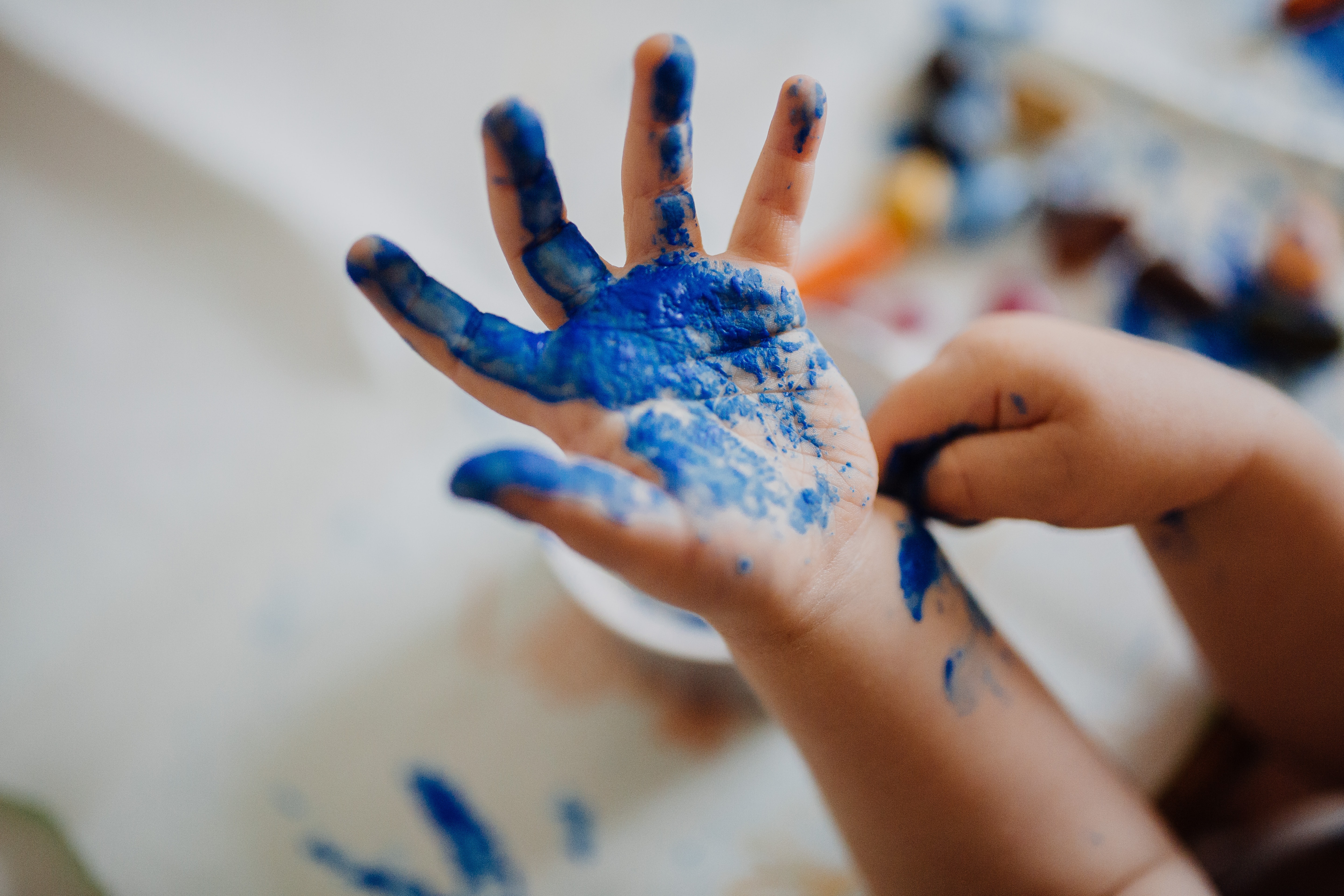 little kid hand covered in blue paint