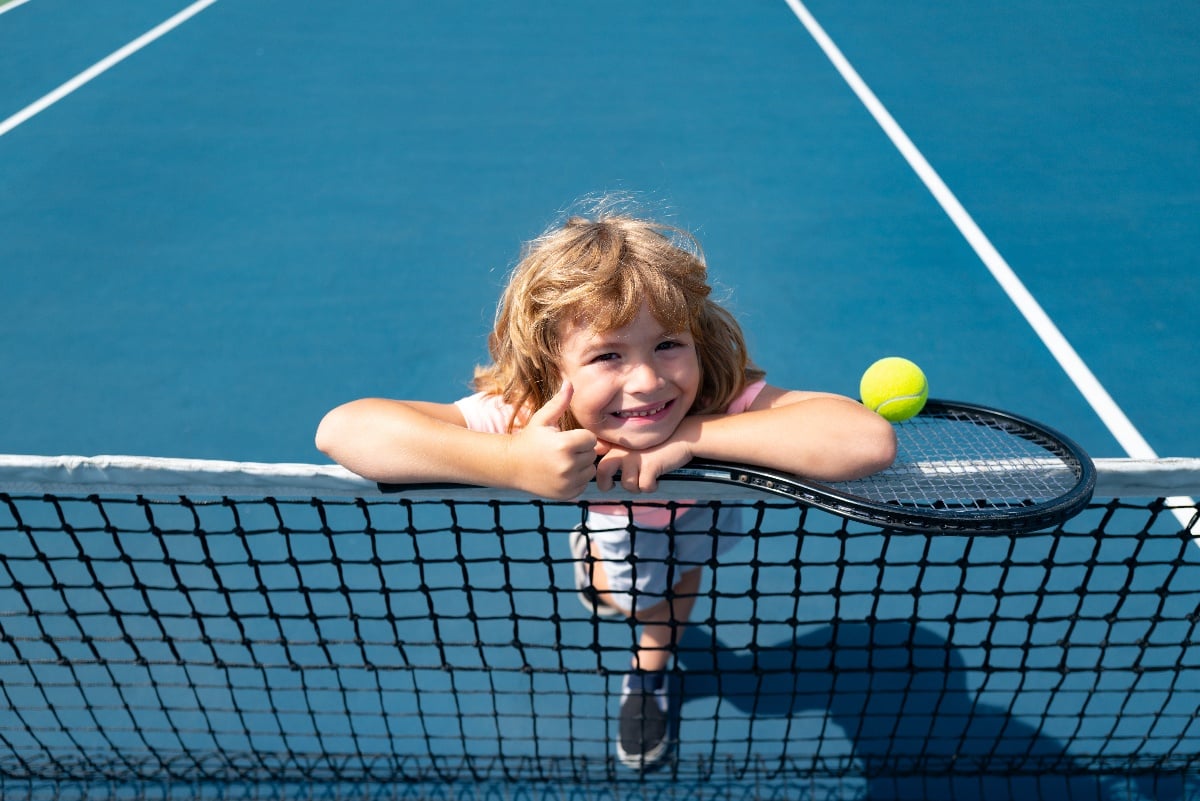 how to get your  child involved in tennis cover photo of kid playing tennis